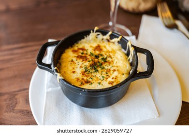 Classic Normandy-style baked egg served in creamy melted Camembert cheese, a rich and comforting regional specialty perfect for cheese lovers.