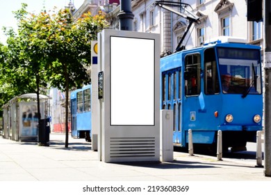 Classic Old Blue Tram In Closeup At Streetcar Stop. White Blank Lightbox Ad Panel On The Side. Poster And Advertising Billboard Sign. Mockup Base. Business Communication Placeholder. Soft Background.