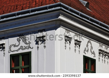 classic old window head elevation detail. metal roof edge flashing. decorative stucco elements. red clay tile sloped roof. gray Zink gutter and dormer. sharp needle type bird or pigeon repellent strip