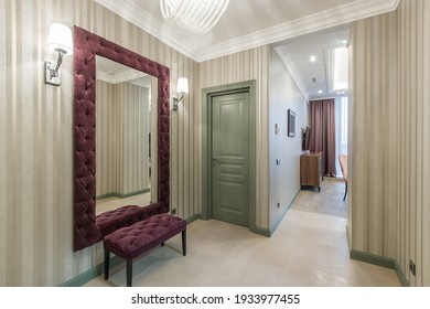 The Classic Olive Built-in Wardrobe In The Corner Of The Hall. A Mirror Hanging In Front Of The Entrance Door.A Purple Velvet Couch Standing In From Of The Mirror.