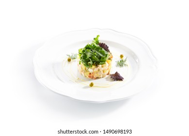 Classic Olivier Salad Or Russian Salad With Chicken Fillet, Quail Eggs, Pickles, Greens And Peas On White Plate Isolated. Traditional Christmas Salat Or Stolichny Salad On A White Plate In Restaurant