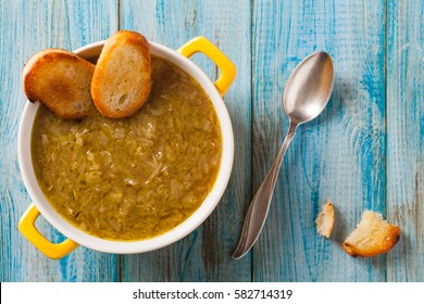 Classic Onion Soup With Croutons. Served In Yellow Bowl On Blue Boards. Top View.