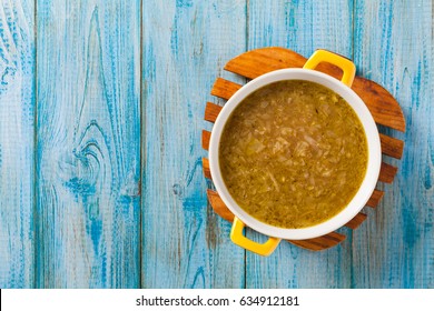 Classic Onion Soup With Croutons. Served In Yellow Bowl On Blue Boards. Top View.