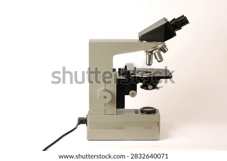 Classic optical microscope designed for laboratory observation and scientific research, featuring a sturdy metal frame, binocular viewing head, objective turret, adjustable stage and focusing mechanism.