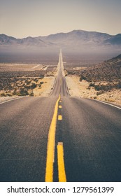 Classic Panorama View Of An Endless Straight Road Running Through The Barren Scenery Of The American Southwest With Extreme Heat Haze In The Background On A Beautiful Hot Sunny Day In Summer