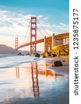 Classic panoramic view of famous Golden Gate Bridge seen from scenic Baker Beach in beautiful golden evening light on a sunny day with blue sky and clouds in summer, San Francisco, California, USA