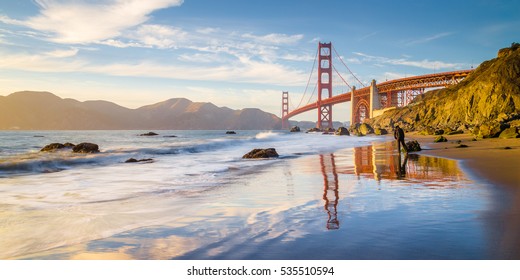 Classic panoramic view of famous Golden Gate Bridge seen from scenic Baker Beach in beautiful golden evening light on a sunny day with blue sky and clouds in summer, San Francisco, California, USA - Shutterstock ID 535510594