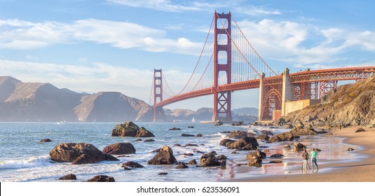 Classic panoramic view of famous Golden Gate Bridge seen from scenic Baker Beach in beautiful golden evening light on a sunny day with blue sky and clouds in summer, San Francisco, California, USA - Shutterstock ID 623536091