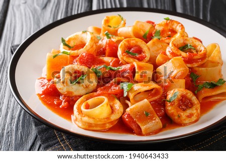 Classic Pasta Calamarata with squid sauce Italian Recipe close-up in a plate on the table. Horizontal
