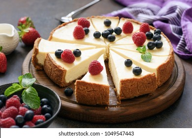 Classic plain New York Cheesecake sliced on wooden board, closeup view, selective focus - Powered by Shutterstock