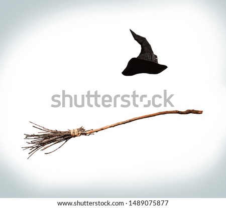 classic pointed witch hat and flying broom flying on a white background