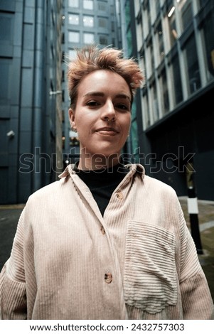 Classic portrait of young alternative woman made with wide-angle lens in a cosmopolitan environment. Exaggerated point of view.