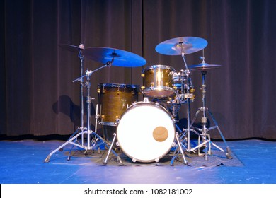 Classic Professional Basic Drum Kit Set On A Stage With Black Curtains In The Background.