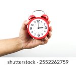 A classic red alarm clock in hand on a white isolated background