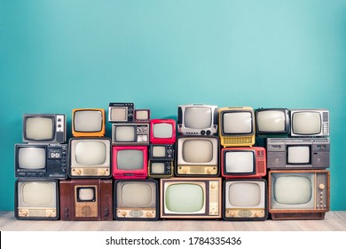 Classic retro CRT TV receivers set collection from circa 50s, 60s, 70s and 80s of XX century front mint blue wall background. Media broadcasting or live news concept. Vintage old style filtered photo