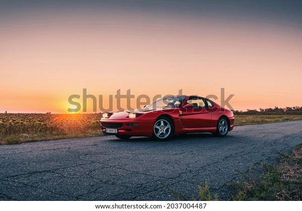 Classic retro Ferrari 456GTA\
finished in red on the sunset. Kherson, Ukraine - August\
2021.