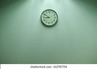 Classic round wall clock on the wall background.