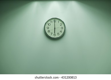 Classic round wall clock on the wall background.