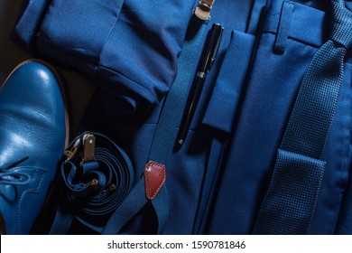 Classic Set Men Clothes Blue Suit, Shoes, Belt, Watches, Notebook, Speaker On Dark Background. Top View. Flat Lay