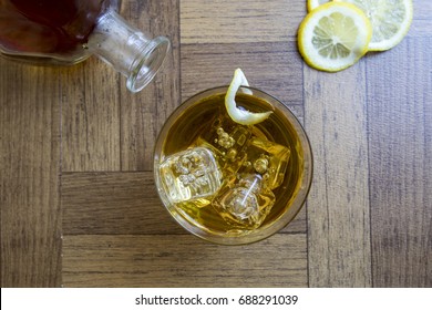 Classic Side Car Cocktail Garnished With Lemon Twist Over Ice With Bottle And Lemon Slices.