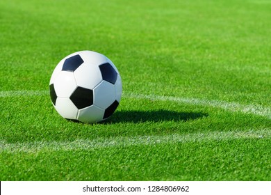 A Classic Soccer Ball Lies On The Bright Green Grass On The Football Field In The Designated Area Of The Penalty Area At A Sports Stadium Close-up In A Large Sports Center For Football Players