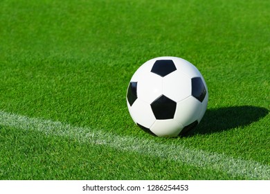 A Classic Soccer Ball Lies On The Bright Green Grass On The Football Field In The Designated Area Of The Penalty Area At A Sports Stadium Close-up In A Large Sports Center For Football Players