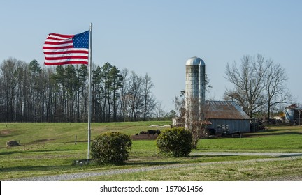 Classic Storage Silos On A Working Farm With American Flag In The Yard