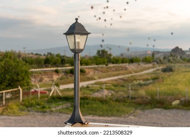 Classic street lamp, balloons flying over green plain in background. - Powered by Shutterstock