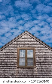 A Classic Style East Coast Home On Nantucket Island With A Unique Cloud Pattern Above.