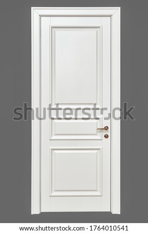 Classic style white door. White interior door with golden handle isolated on gray background. Furniture manufacture.