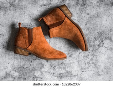 Classic suede brown women's chelsea boots on a gray background, top view                          