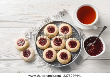 Classic Swedish Raspberry Thumbprint Cookiescloseup on the plate on the white wooden table. Horizontal top view from above
