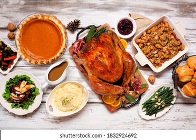 Classic Thanksgiving Turkey Dinner. Overhead View Table Scene On A Rustic White Wood Background. Turkey, Mashed Potatoes, Stuffing, Pumpkin Pie And Sides.