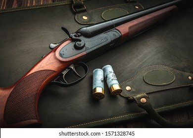 Classic trigger double-barreled hunting rifle on a green background. Smooth-bore hunting rifle open for reloading. Concept postcards for hunters.