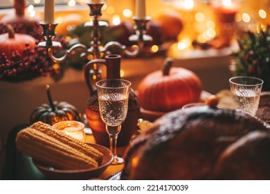 Classic USA Thanksgiving Day Dinner With Holiday Autumn Decor And Candles. Family Dining Room Table Set With Delicious Golden Roasted Turkey On Platter Garnished Rosemary And Fresh Small Pumpkins