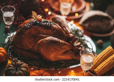 Classic USA Thanksgiving Day Dinner With Holiday Autumn Decor And Candles. Family Dining Room Table Set With Delicious Golden Roasted Turkey On Platter Garnished Rosemary And Fresh Small Pumpkins