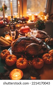 Classic USA Thanksgiving Day Dinner With Holiday Autumn Decor And Candles. Family Dining Room Table Set With Delicious Golden Roasted Turkey On Platter Garnished Rosemary And Fresh Small Pumpkins