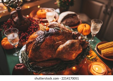 Classic USA Thanksgiving Day Dinner With Holiday Autumn Decor And Candles. Family Dining Room Table Set With Delicious Golden Roasted Turkey On Platter Garnished Rosemary And Fresh Small Pumpkins