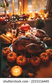 Classic USA Thanksgiving Day Dinner With Holiday Autumn Decor And Candles. Family Dining Room Table Set With Delicious Golden Roasted Turkey On Platter Garnished Rosemary And Fresh Small Pumpkins