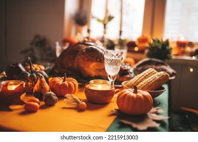 Classic USA Thanksgiving Day Dinner With Holiday Autumn Decor And Candles. Family Dining Room Table Set With Delicious Golden Roasted Turkey On Platter Garnished Rosemary And Fresh Small Pumpkins