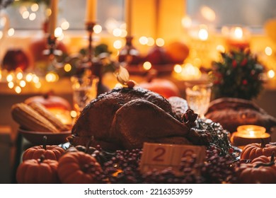 Classic USA Thanksgiving Day Dinner With Holiday Autumn Decor And Candles. Family Dining Room Table Set With Delicious Golden Roasted Turkey On Platter Garnished Rosemary And Fresh Small Pumpkins