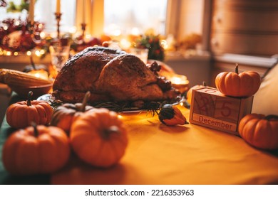 Classic USA Thanksgiving Day Dinner With Holiday Autumn Decor And Candles. Family Dining Room Table Set With Delicious Golden Roasted Turkey On Platter By Wooden Block Calendar Small Pumpkins And Corn