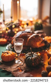 Classic USA Thanksgiving Day Dinner With Holiday Autumn Decor And Candles. Family Dining Room Table Set With Delicious Golden Roasted Turkey On Platter Garnished Rosemary And Fresh Small Pumpkins