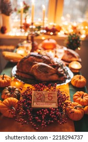 Classic USA Thanksgiving Day Dinner With Holiday Autumn Decor And Candles. Family Dining Room Table Set With Delicious Golden Roasted Turkey On Platter By Wooden Block Calendar Small Pumpkins And Corn