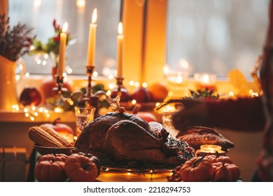 Classic USA Thanksgiving Day Dinner With Holiday Autumn Decor And Candles. Family Dining Room Table Set With Delicious Golden Roasted Turkey On Platter Garnished Rosemary And Fresh Small Pumpkins