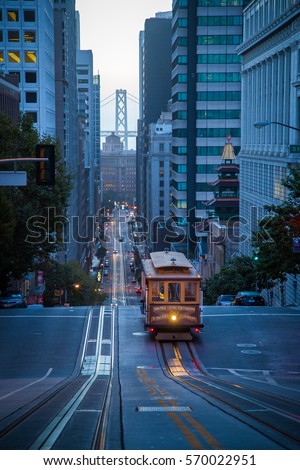 Classic vertical view of historic Cable Car riding on famous empty California Street in beautiful early morning twilight before sunrise in summer, San Francisco, California, USA