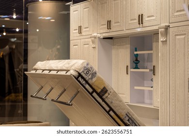 Classic vertical wall bed system with open storage shelves and wood panel doors, presented in a showroom for space-saving furniture solutions ideal for urban apartments or multifunctional guest rooms
