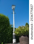 A classic Victorian style street light. Cast iron painted black and white, this vintage piece was manufactured by the now defunct Revo Tipton company.