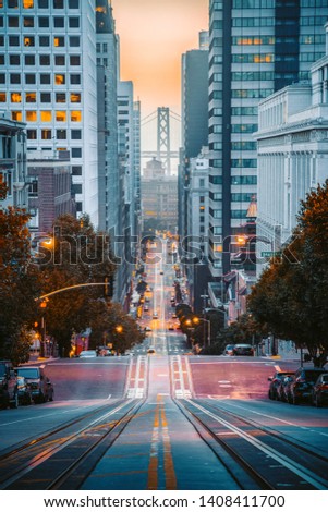 Classic view of downtown San Francisco with famous Oakland Bay Bridge illuminated in first golden morning light at sunrise in summer, San Francisco, California, USA