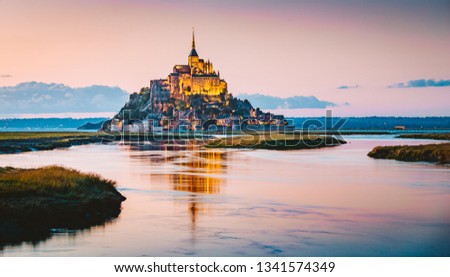 Classic view of famous Le Mont Saint-Michel tidal island in beautiful evening twilight at dusk, Normandy, northern France